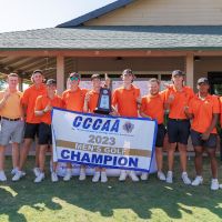 men's golf standing with state championship banner
