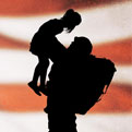 soldier holding daughter in front of flag