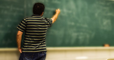 teacher writing on chalkboard
