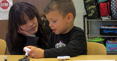 teacher with young student looking in a book