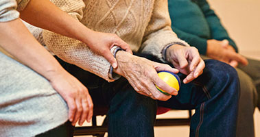elderly person with workout ball in hand