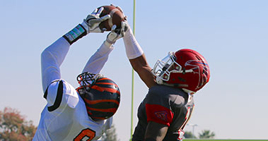 Reedley football player catching ball in air.
