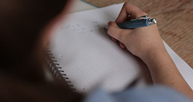 student writing on notebook